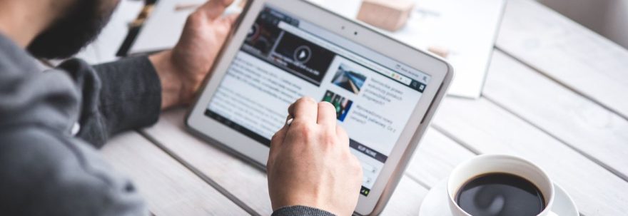 Persoană care citește conținut editorial online pe o tabletă