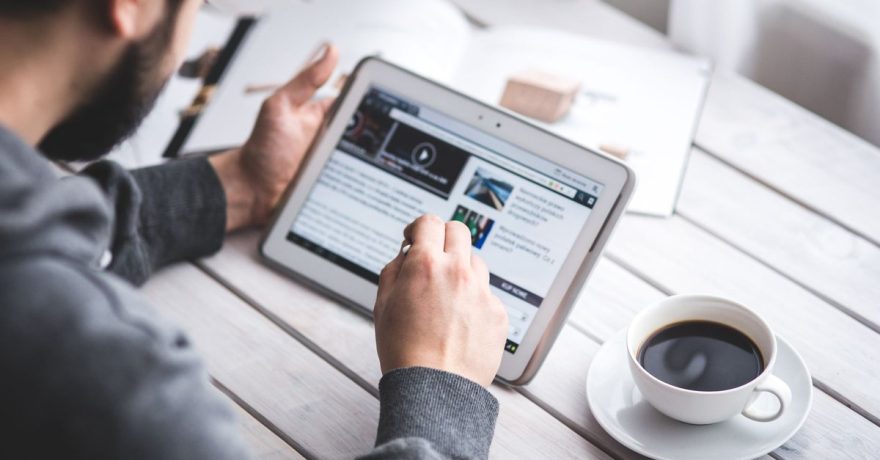 Persoană care citește conținut editorial online pe o tabletă